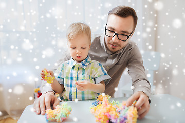 Image showing father and son playing with ball clay at home