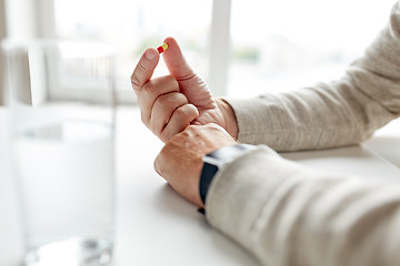 Image showing close up of old man hands with pill