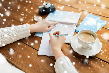 Image showing hands with map and coffee writing to notebook