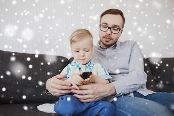 Image showing father and son with remote watching tv at home