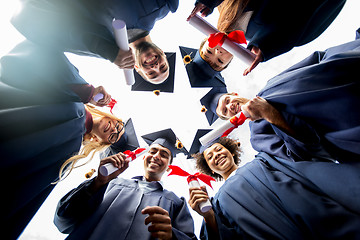 Image showing happy students or bachelors with diplomas