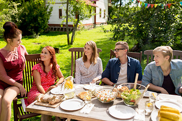 Image showing happy friends having dinner at summer garden party