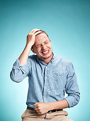 Image showing The disappointed young man over blue background