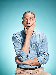 Image showing The surprised young man over blue background