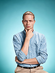 Image showing The serious young man over blue background