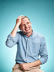 Image showing The disappointed young man over blue background