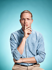 Image showing The serious young man over blue background