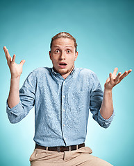 Image showing The surprised young man over blue background