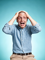 Image showing The disappointed young man over blue background