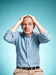 Image showing The disappointed young man over blue background