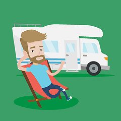 Image showing Man sitting in chair in front of camper van.