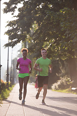 Image showing young multiethnic couple jogging in the city