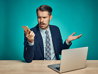 Image showing Sad Young Man Working On Laptop At Desk