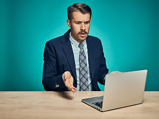 Image showing Sad Young Man Working On Laptop At Desk