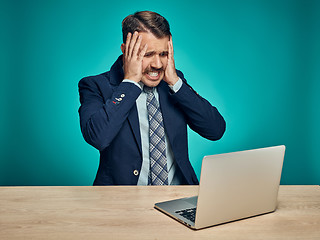 Image showing Sad Young Man Working On Laptop At Desk