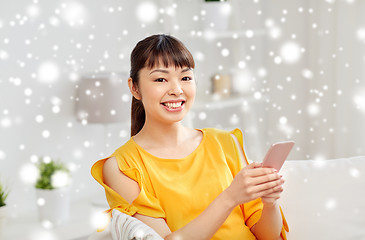 Image showing happy asian woman with smartphone at home