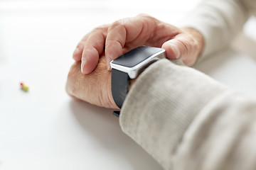 Image showing close up of old man hand with pill and smart watch