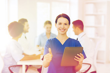 Image showing happy doctor with tablet pc over team at clinic