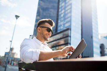 Image showing man with tablet pc sitting on city street bench