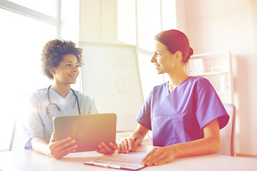 Image showing happy doctors with tablet pc meeting at hospital