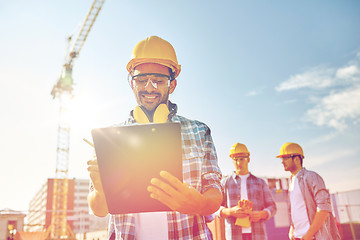 Image showing builder in hardhat with clipboard at construction