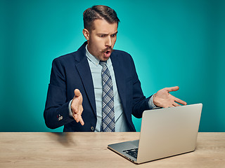 Image showing Sad Young Man Working On Laptop At Desk