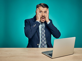 Image showing Sad Young Man Working On Laptop At Desk