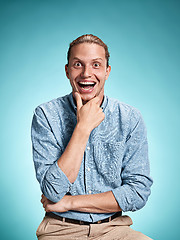 Image showing Happy excite young man smiling over blue background