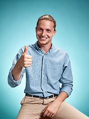 Image showing Happy excite young man smiling over blue background