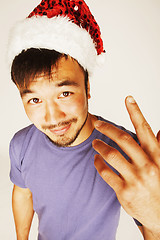 Image showing funy exotical asian Santa claus in new years red hat smiling