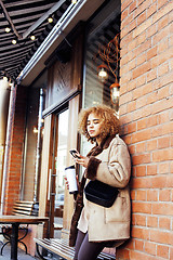 Image showing young pretty african american women drinking coffee outside in c