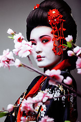 Image showing young pretty geisha in kimono sakura view