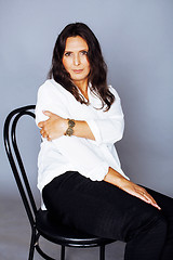 Image showing pretty brunette confident mature woman sitting on chair in studi