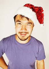 Image showing funy exotical asian Santa claus in new years red hat smiling