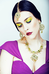 Image showing young pretty caucasian woman like indian in ethnic jewelry close up on white, bridal makeup