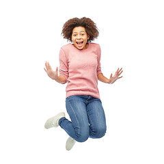 Image showing happy african american woman jumping over white