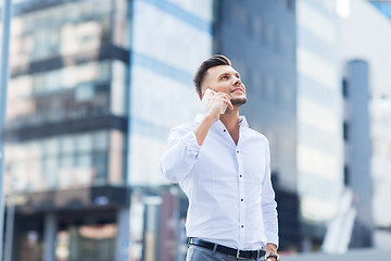 Image showing happy man with smartphone calling on city street