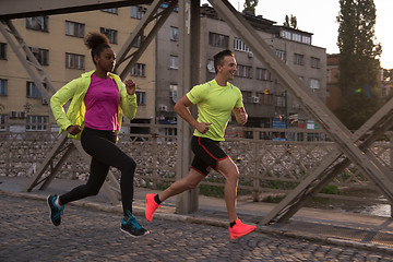 Image showing young multiethnic couple jogging in the city