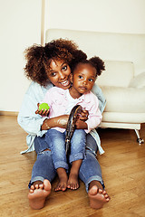 Image showing adorable sweet young afro-american mother with cute little daughter, hanging at home, having fun playing smiling, lifestyle people concept, happy smiling modern family