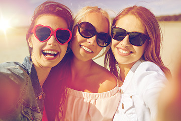 Image showing group of smiling women taking selfie on beach