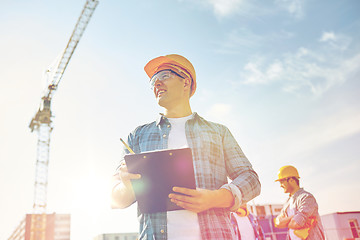 Image showing builder in hardhat with clipboard at construction