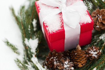 Image showing close up of christmas gift and fir wreath on snow