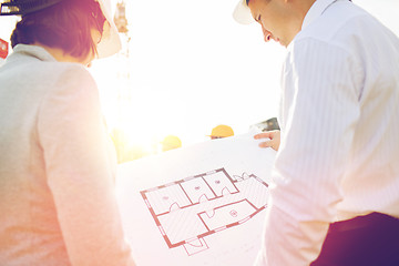 Image showing close up of architects with blueprint at building