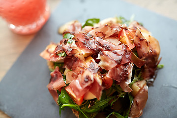 Image showing prosciutto ham salad on stone plate at restaurant