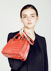 Image showing young pretty cool fashion business lady wearing black suit and orange little bag smiling on white background, lifestyle people concept