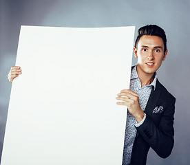 Image showing young pretty business man standing on white background, modern hairstyle, posing emotional, lifestyle people concept, holding copyspace shit