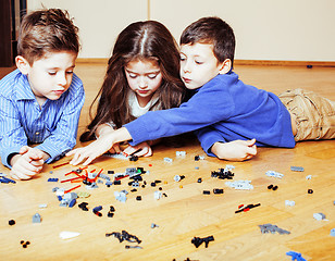 Image showing funny cute children playing lego at home, boys and girl smiling, first education role lifestyle