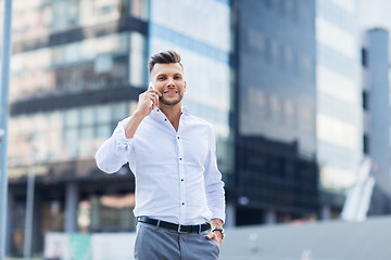 Image showing happy man with smartphone calling on city street