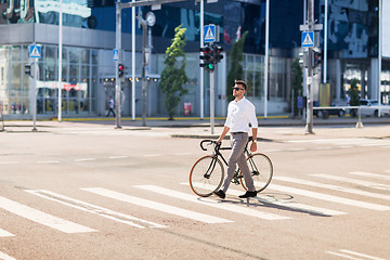 Image showing young man with bicycle on crosswalk in city