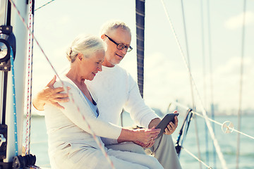 Image showing senior couple with tablet pc on sail boat or yacht